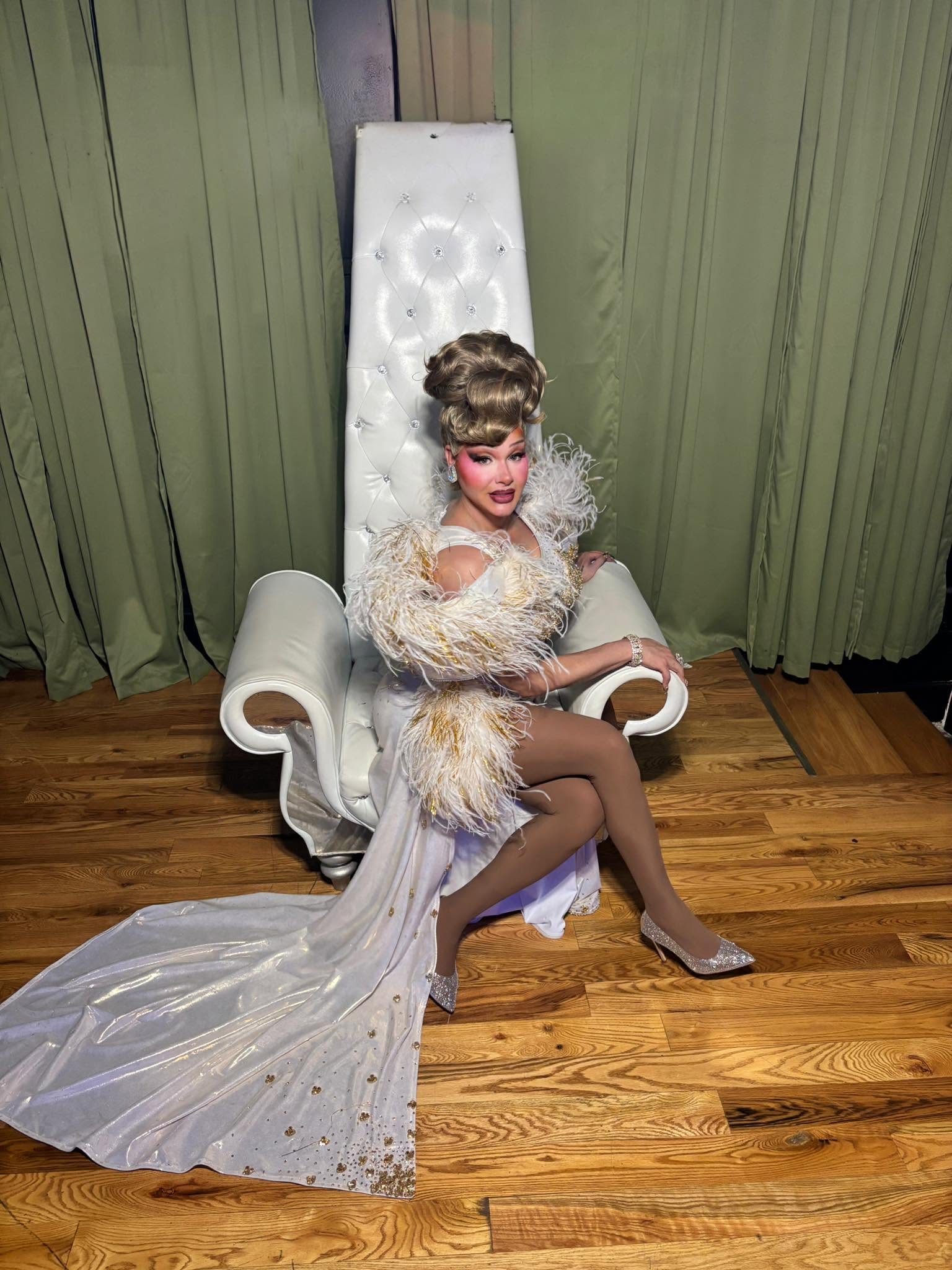Amaya Sexton in white feathers on a throne